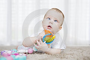 Cute baby girl holding a toy on the carpet