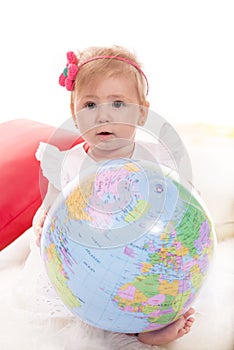 Cute baby girl holding world globe