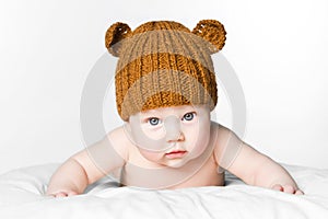 Cute baby girl in knitted cap teddy bear. concept of skin care of newborn child.