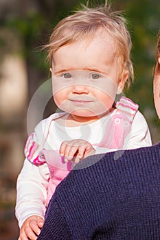 Cute baby girl looking out from mother's back