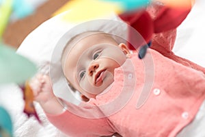 Cute baby girl playing with playmat toys