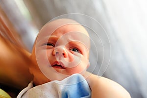 Cute baby girl makes a funny upset face on mothers hand