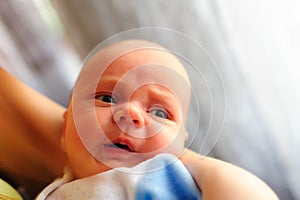 Cute baby girl makes a funny upset face on mothers hand