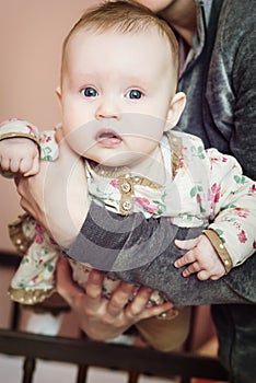 Cute baby girl in mother's arms photo