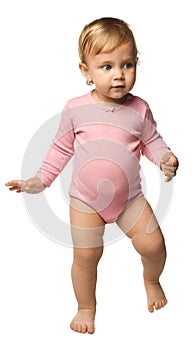 Cute baby girl in pink bodysuit learning to walk on background