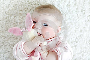 Cute baby girl playing with colorful pastel vintage rattle toy