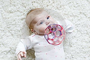 Cute baby girl playing with colorful rattle toy