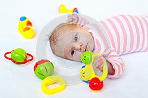 Cute baby girl playing with colorful rattle toys