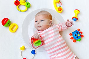 Cute baby girl playing with colorful rattle toys