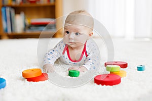 Cute baby girl playing with colorful wooden rattle toy