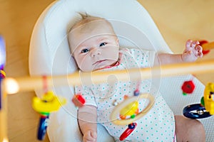 Cute baby girl playing with hanging wooden rattle toys