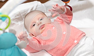 Cute baby girl playing with playmat toys