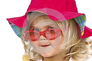 Cute baby girl in a red hat and sunglasses.