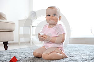 Cute baby girl sitting on floor