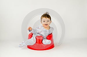 Cute baby girl sitting in a plastic seat