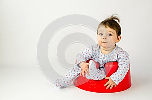 Cute baby girl sitting in a plastic seat