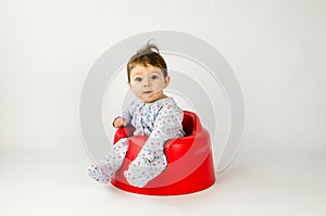 Cute baby girl sitting in a plastic seat