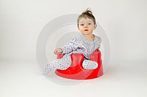 Cute baby girl sitting in a plastic seat