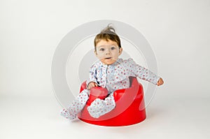 Cute baby girl sitting in a plastic seat