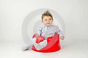 Cute baby girl sitting in a plastic seat