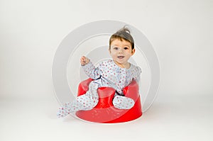 Cute baby girl sitting in a plastic seat