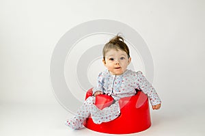 Cute baby girl sitting in a plastic seat