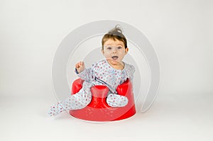 Cute baby girl sitting in a plastic seat