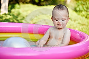 cute baby girl swimming in kid inflatable pool