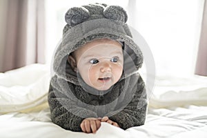 A Cute baby girl on a white bed at home