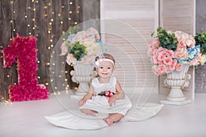 Cute baby girl 1-2 year old sitting on floor with pink balloons in room over white. Isolated. Birthday party. Celebration. Happy b