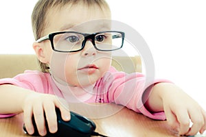 Cute baby with glasses looking into the laptop