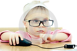 Cute baby with glasses looking into the laptop