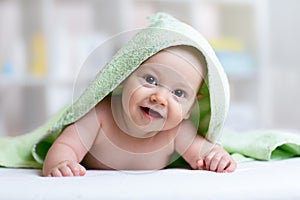 Cute baby in green towel after bathing