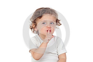 Cute baby has put forefinger to lips as sign of silence