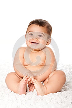 Cute baby infant with big eyes sitting wearing diaper