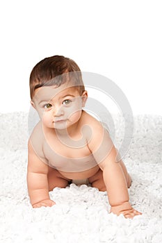 Cute baby infant with big green eyes crawling on white