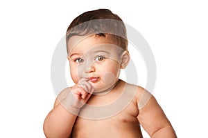 Cute baby infant with big green eyes finger in mouth on white