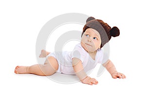 Cute baby in knitted brown hat with ears bears crawls on white