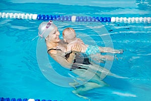 Cute baby learn to swim in pool with her mother