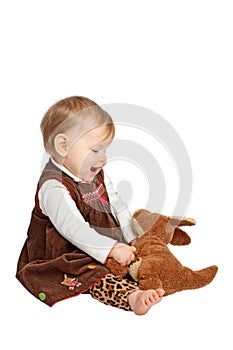 Cute baby looks lovingly at stuffed toy