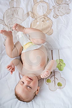 Cute baby lying on bed in bedroom