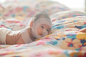 Cute baby lying on the bed in diapers