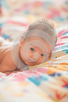 Cute baby lying on the bed in diapers