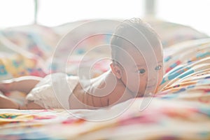 Cute baby lying on the bed in diapers