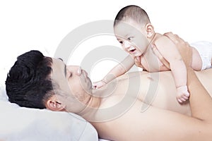 Cute baby lying on chest of father