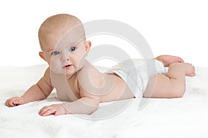 Cute baby lying on white towel in nappy or diaper