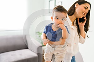 Cute baby with mom talking on phone