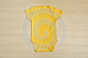 Cute baby onesie on wooden background