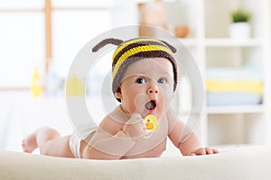 Cute baby with pacifier on the bed at home