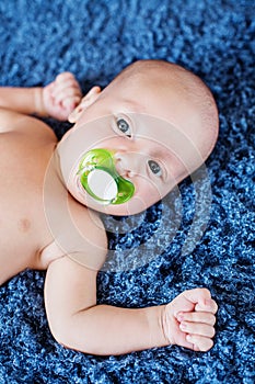 Cute baby with pacifier lying